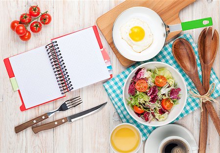 Healthy breakfast with fried egg, toasts and salad on white wooden table with notepad for copy space Stock Photo - Budget Royalty-Free & Subscription, Code: 400-08037266