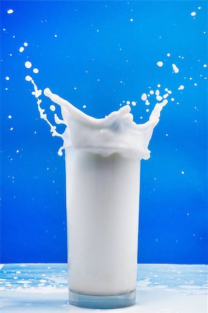 drop milk - Splash of milk from the glass on a blue background Stock Photo - Budget Royalty-Free & Subscription, Code: 400-08037479