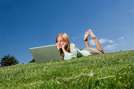 Woman with computer in the grass towards blue sky Photographie de stock - Aubaine LD & Abonnement, Code: 400-08032424