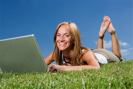 Woman with computer in the grass towards blue sky Photographie de stock - Aubaine LD & Abonnement, Code: 400-08032425