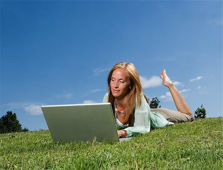 Woman with computer in the grass towards blue sky Photographie de stock - Aubaine LD & Abonnement, Code: 400-08032421