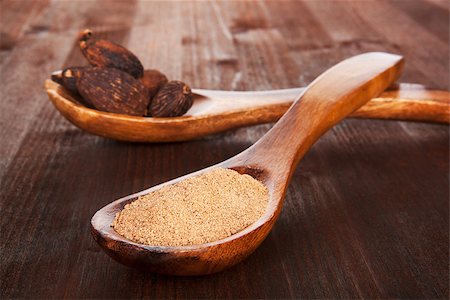 simsearch:652-02222267,k - Grated nutmeg in wooden spoon and whole nutmegs on wooden spoon in background on dark wooden background. Culinary aromatic spice. Stockbilder - Microstock & Abonnement, Bildnummer: 400-08033127