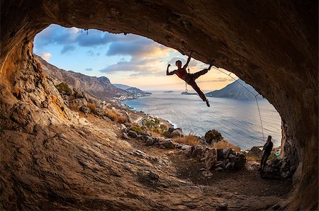 simsearch:400-07292725,k - Female rock climber posing while climbing along roof in cave at sunset Photographie de stock - Aubaine LD & Abonnement, Code: 400-08033196