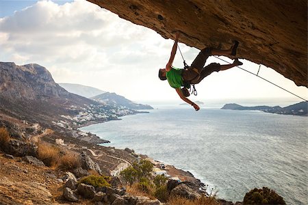 simsearch:400-07292725,k - Male climber on overhanging rock against beautiful view of coast below Photographie de stock - Aubaine LD & Abonnement, Code: 400-08033193