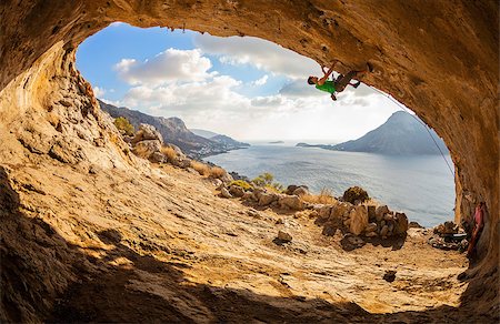 simsearch:400-07292725,k - Young man lead climbing in cave with beautiful view in background Photographie de stock - Aubaine LD & Abonnement, Code: 400-08033202