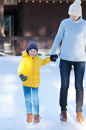 simsearch:400-08318063,k - happy family of mother and her son enjoying ice skating together at winter at outdoor skating rink Photographie de stock - Aubaine LD & Abonnement, Code: 400-08033349