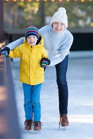 simsearch:400-08318063,k - happy family of mother and her son enjoying ice skating together at winter at outdoor skating rink Photographie de stock - Aubaine LD & Abonnement, Code: 400-08033353