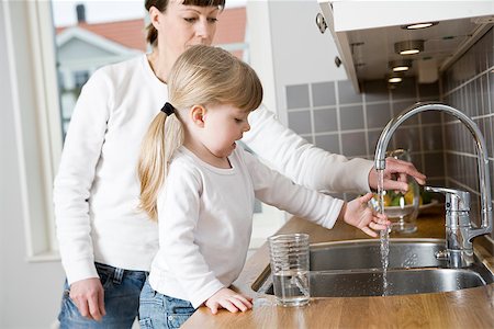 Small Girl in the kitchen with her mother drinking water Stock Photo - Budget Royalty-Free & Subscription, Code: 400-08033584