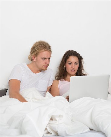 Married couple with a laptop in bed Stock Photo - Budget Royalty-Free & Subscription, Code: 400-08033693