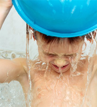 Seven years boy pouring water from a basin on his head Foto de stock - Super Valor sin royalties y Suscripción, Código: 400-08044143