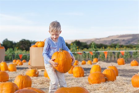 simsearch:400-07169847,k - little excited kid  enjoying time at pumpkin patch holding big pumpkin in hands Photographie de stock - Aubaine LD & Abonnement, Code: 400-08046455