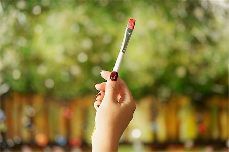 Closeup of woman hand holding painting brush and studying composition of picture on canvas Stock Photo - Budget Royalty-Free & Subscription, Code: 400-08042468