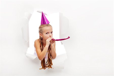Little party girl with hat and whistle looking out on blast hole in paper - with copy space Stock Photo - Budget Royalty-Free & Subscription, Code: 400-08043104