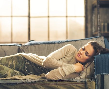 simsearch:400-08054469,k - Cat-nap on a sofa. An elegant brunette woman napping on a sofa in a loft, curling her hands under her chin. Urban chic ambiance. Stock Photo - Budget Royalty-Free & Subscription, Code: 400-08054464