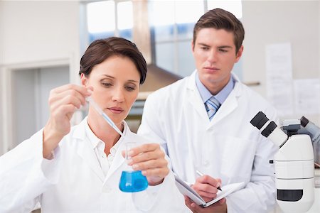 simsearch:400-08055396,k - Scientists examining attentively pipette with blue fluid in laboratory Stock Photo - Budget Royalty-Free & Subscription, Code: 400-08054805