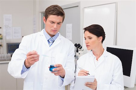 simsearch:400-08055396,k - Scientists examining attentively pipette with blue fluid in laboratory Stock Photo - Budget Royalty-Free & Subscription, Code: 400-08054806