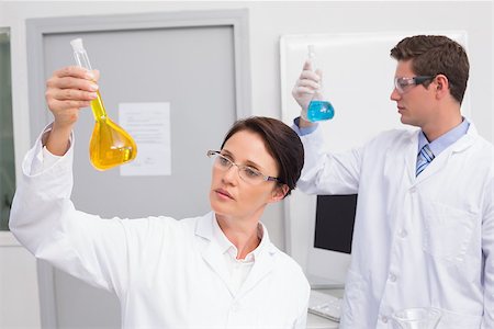 simsearch:400-08055357,k - Scientists looking attentively at beakers in laboratory Stock Photo - Budget Royalty-Free & Subscription, Code: 400-08054855