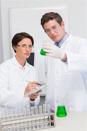 simsearch:400-08055396,k - Scientists examining attentively beaker with green fluid in laboratory Stock Photo - Budget Royalty-Free & Subscription, Code: 400-08054850