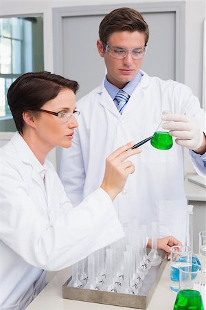 simsearch:400-08055396,k - Scientists examining attentively beaker with green fluid in laboratory Stock Photo - Budget Royalty-Free & Subscription, Code: 400-08054852