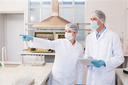 simsearch:6109-08389507,k - Scientist showing something to her colleague in laboratory Stock Photo - Budget Royalty-Free & Subscription, Code: 400-08054900