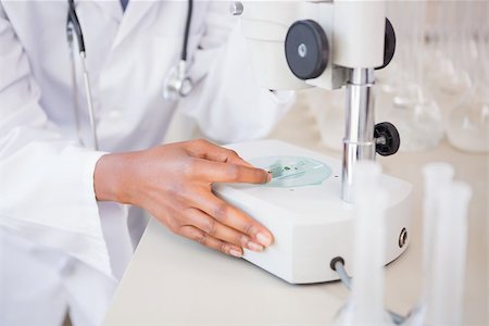 simsearch:400-08055396,k - Scientist looking at petri dish under microscope in laboratory Stock Photo - Budget Royalty-Free & Subscription, Code: 400-08055349