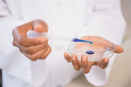 simsearch:400-08055390,k - Scientist examining blue fluid in petri dish in laboratory Stock Photo - Budget Royalty-Free & Subscription, Code: 400-08055396