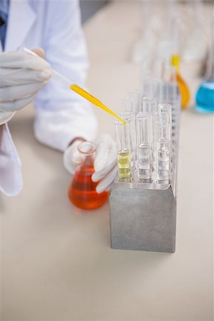 simsearch:400-08055390,k - Scientist pouring orange fluid in test tube in laboratory Stock Photo - Budget Royalty-Free & Subscription, Code: 400-08055392