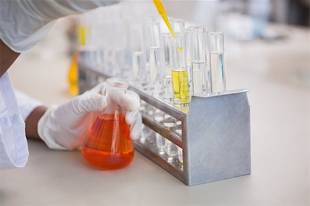 simsearch:400-08055357,k - Scientist pouring orange fluid in test tube in laboratory Stock Photo - Budget Royalty-Free & Subscription, Code: 400-08055393