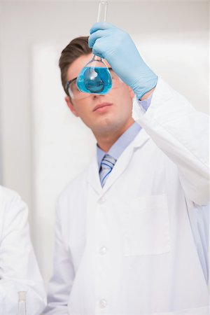 simsearch:400-08055390,k - Scientist looking at beaker with blue fluid in laboratory Stock Photo - Budget Royalty-Free & Subscription, Code: 400-08055420