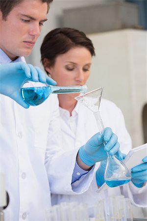 simsearch:400-08055390,k - Scientists pouring chemical fluid in funnel in laboratory Stock Photo - Budget Royalty-Free & Subscription, Code: 400-08055438