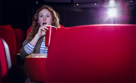 simsearch:693-03707208,k - Young woman watching a film and drinking a soda at the cinema Photographie de stock - Aubaine LD & Abonnement, Code: 400-08055642