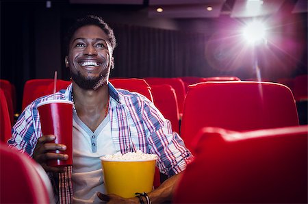 simsearch:400-08055721,k - Happy young man watching a film at the cinema Foto de stock - Royalty-Free Super Valor e Assinatura, Número: 400-08055690