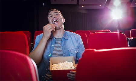 simsearch:400-08055721,k - Happy young man watching a film at the cinema Foto de stock - Royalty-Free Super Valor e Assinatura, Número: 400-08055732