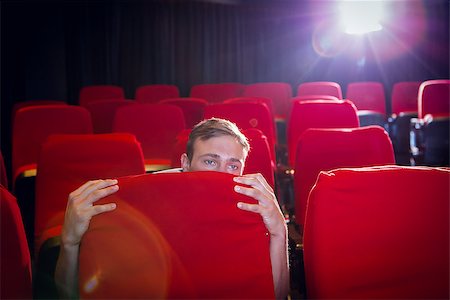 people scared movie theatre - Young man watching a scary film at the cinema Stock Photo - Budget Royalty-Free & Subscription, Code: 400-08055746