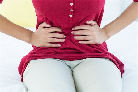 simsearch:400-06106822,k - Woman sitting on bed with stomach pain at home Stockbilder - Microstock & Abonnement, Bildnummer: 400-08056080