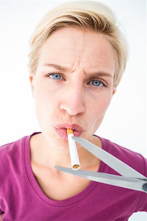simsearch:400-06876304,k - Beautiful blonde cutting a cigarette on white background Stock Photo - Budget Royalty-Free & Subscription, Code: 400-08056200