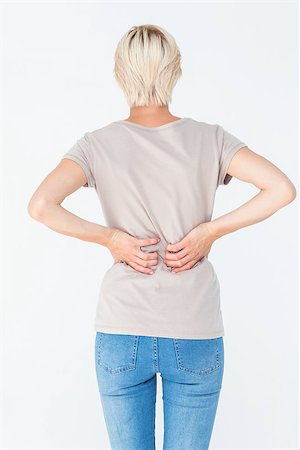 Blonde woman having a back ache and holding her back on white background Stock Photo - Budget Royalty-Free & Subscription, Code: 400-08056262