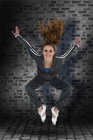 Full length of a sporty young blond jumping against dark grey room Stock Photo - Budget Royalty-Free & Subscription, Code: 400-08056456