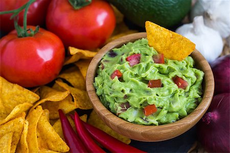 eating chips dip - Guacamole in Wooden Bowl with Tortilla Chips and Ingredients Stock Photo - Budget Royalty-Free & Subscription, Code: 400-08052482