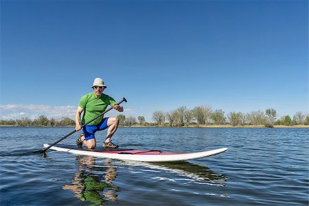 simsearch:400-07795226,k - Senior male exercising on stand up paddling (SUP) board. Early spring on a calm lake in Fort Collins, Colorado.. Foto de stock - Royalty-Free Super Valor e Assinatura, Número: 400-08052998