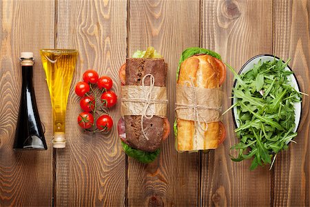 simsearch:400-07099478,k - Two sandwiches with salad, ham, cheese and tomatoes, salad and spices on wooden table. Top view with copy space Stock Photo - Budget Royalty-Free & Subscription, Code: 400-08074763