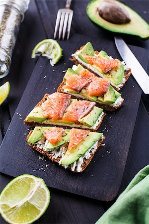 sandwich with avocado - Sandwich with avocado and smoked salmon on a black wooden board Stock Photo - Budget Royalty-Free & Subscription, Code: 400-08075340