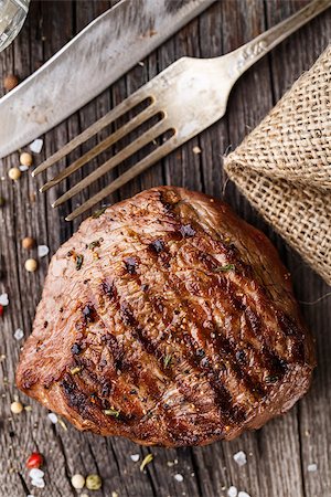 steak knife - Delicious grilled beef steak on a wooden board with spices Photographie de stock - Aubaine LD & Abonnement, Code: 400-08075459