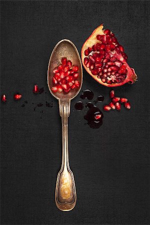 simsearch:640-02656973,k - Delicious ripe pomegranate seeds with silver spoon on black background, top view. Healthy exotic fruit eating. Fotografie stock - Microstock e Abbonamento, Codice: 400-08075949