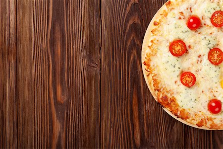 simsearch:400-05682309,k - Italian pizza with cheese, tomatoes and basil on wooden table. Top view with copy space Stock Photo - Budget Royalty-Free & Subscription, Code: 400-08076126