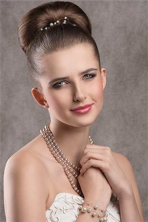simsearch:400-07822212,k - close-up portrait of fine brunette lady with elegant hair-style, stylish make-up and precious pearl necklace. Looking in camera with lovely expression Fotografie stock - Microstock e Abbonamento, Codice: 400-08076196