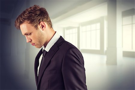 simsearch:400-08020381,k - Young handsome businessman looking down against white room with windows Fotografie stock - Microstock e Abbonamento, Codice: 400-08076535