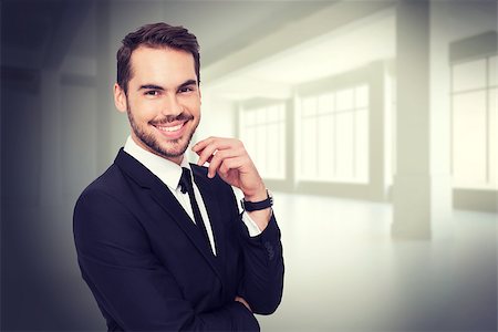 simsearch:400-08020381,k - Stylish businessman smiling at camera against white room with windows Fotografie stock - Microstock e Abbonamento, Codice: 400-08076561