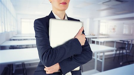 simsearch:700-02121517,k - Businesswoman holding laptop against empty class room Stock Photo - Budget Royalty-Free & Subscription, Code: 400-08076642