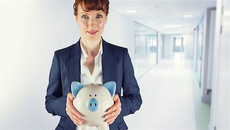 Businesswoman showing piggy bank against college hallway Stock Photo - Budget Royalty-Free & Subscription, Code: 400-08076662